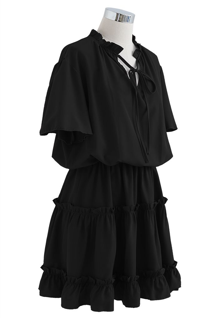 فستان مكشكش بياقة على شكل V وأكمام مضيئة باللون الأسود