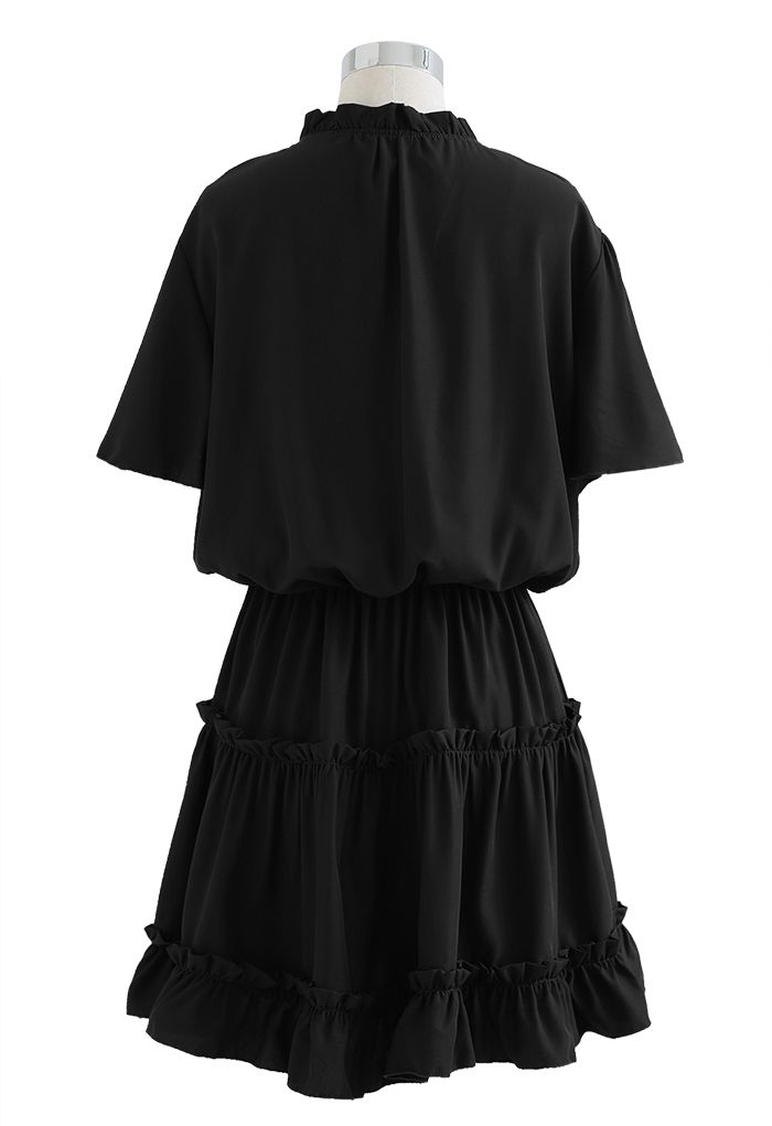 فستان مكشكش بياقة على شكل V وأكمام مضيئة باللون الأسود