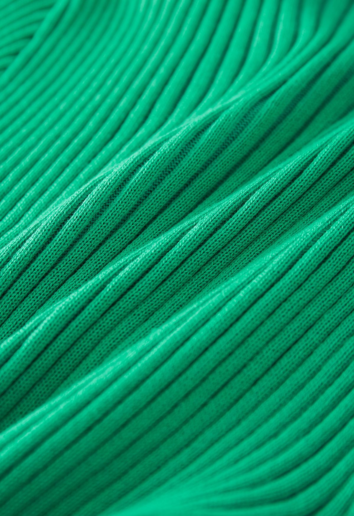 بلوزة محبوكة بياقة على شكل V وتنورة مطوية باللون الأخضر