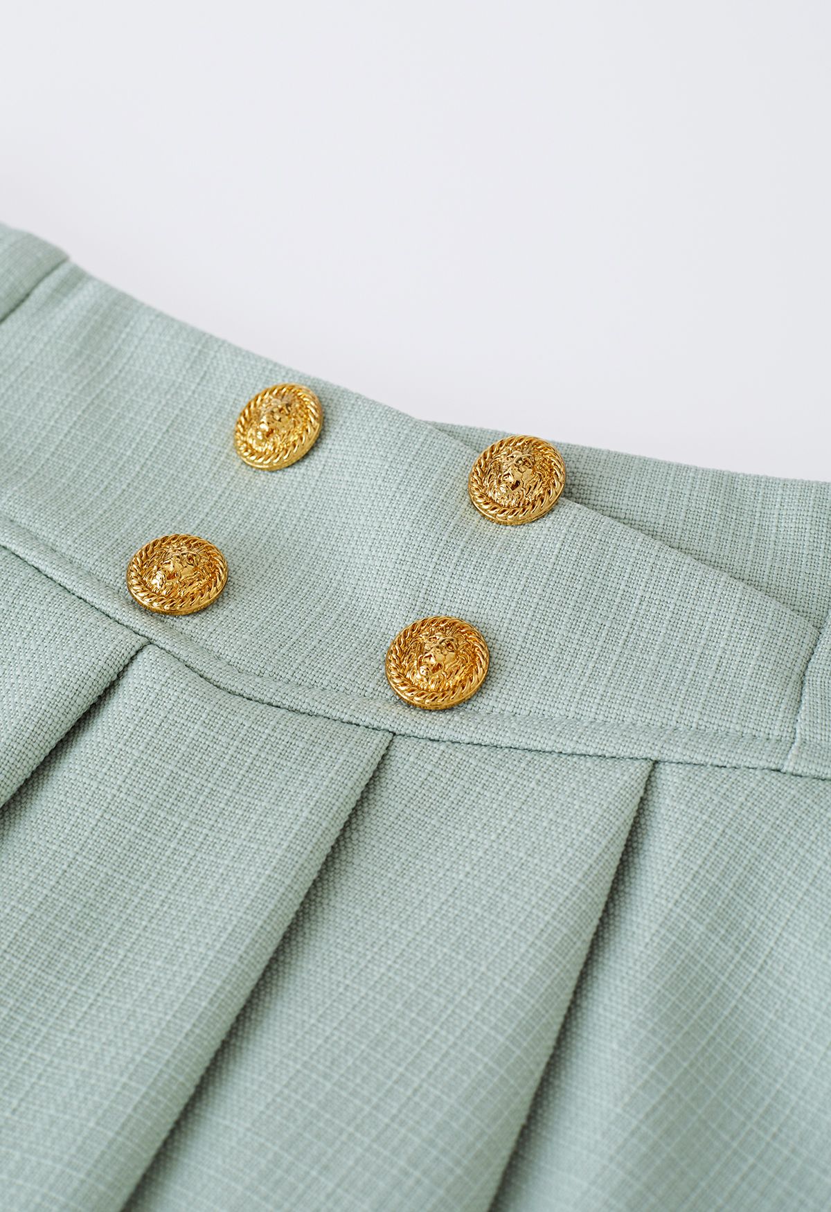 تنورة صغيرة مطوية بأزرار ذهبية في الفستق الحلبي
