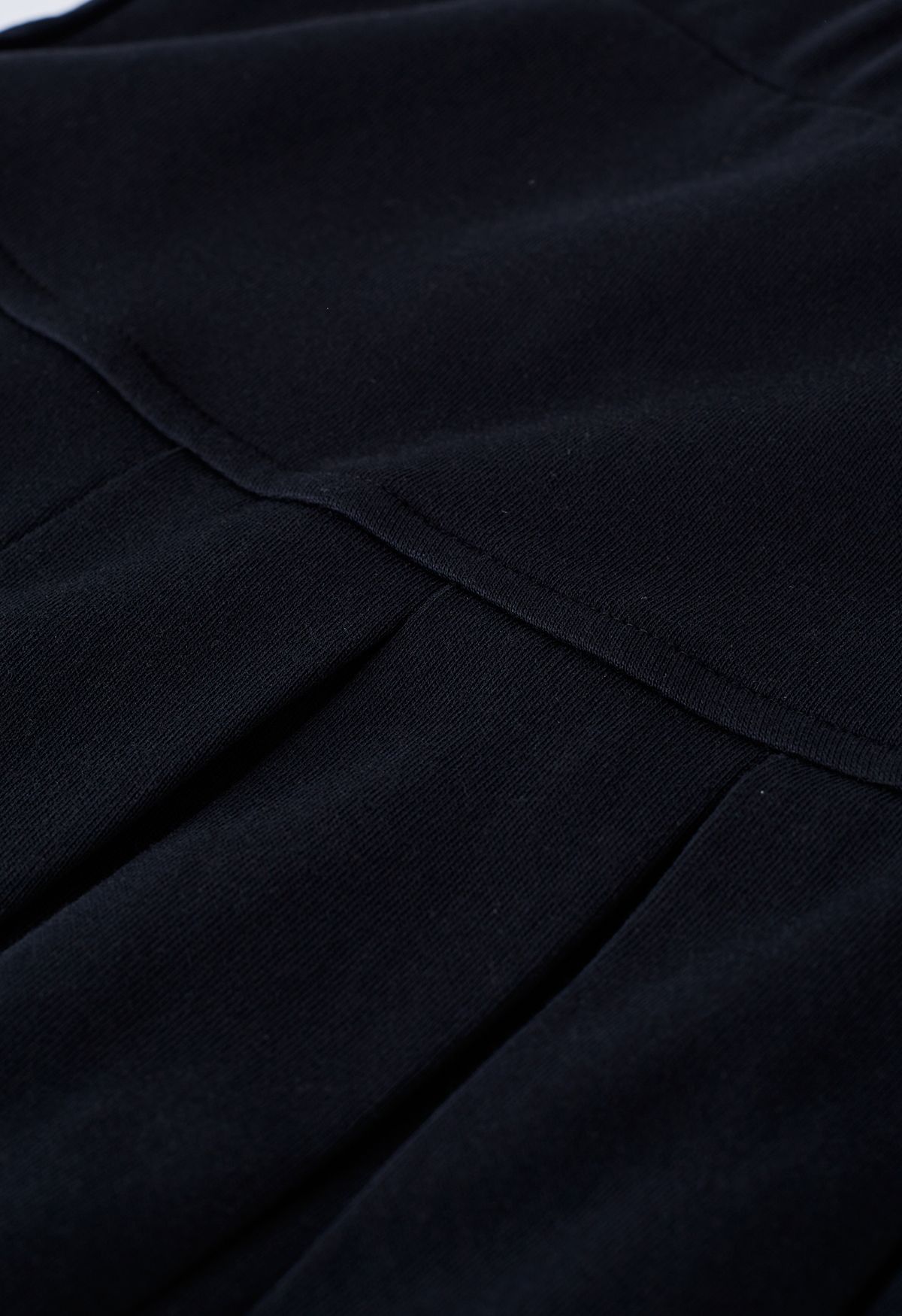 تنورة ميني مضيئة بخصر مطاطي وطيات باللون الأسود
