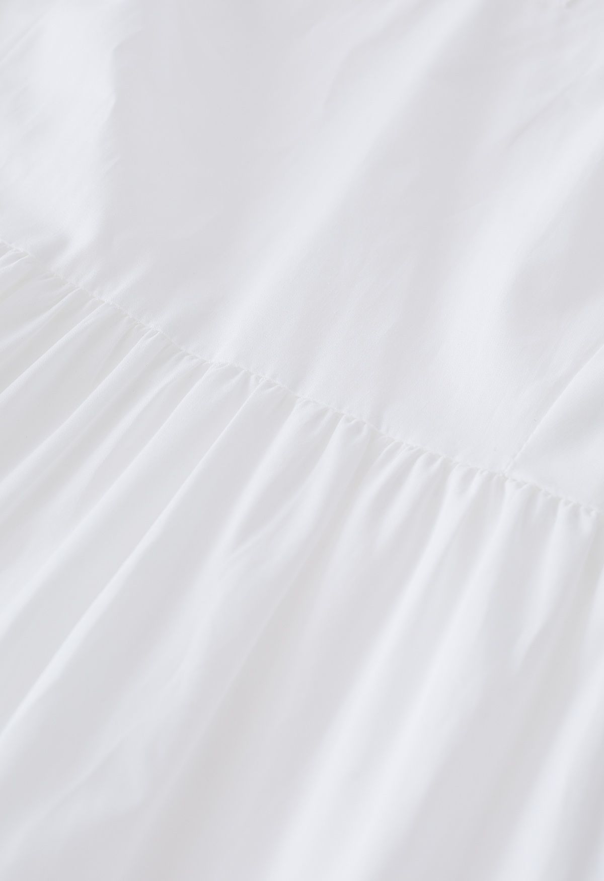 فستان من القطن مكشكش بياقة على شكل V وأكمام رفرفة باللون الأبيض