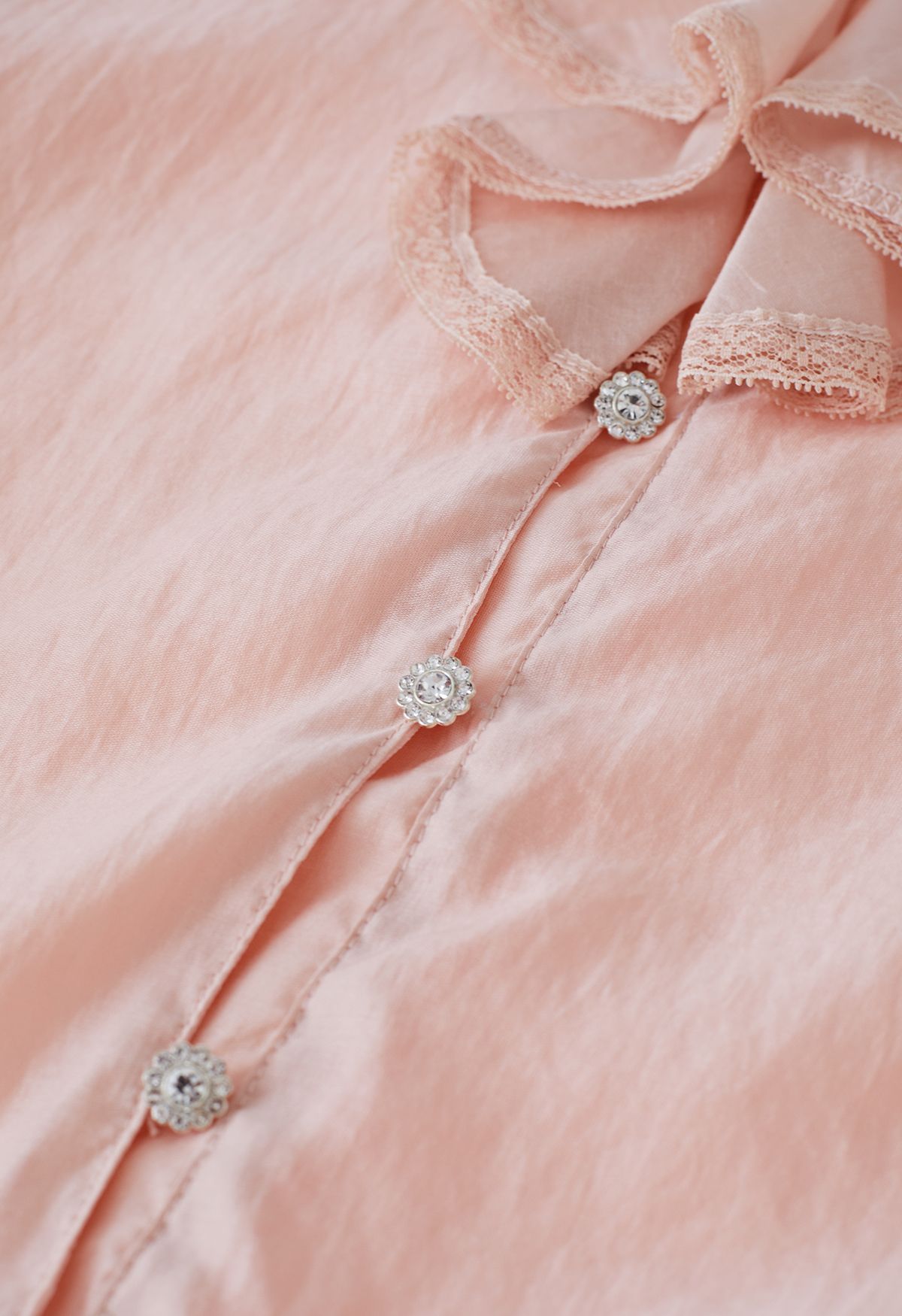 قميص شفاف مكشكش بفتحة رقبة على شكل V وخيط وربطة عنق باللون الخوخي