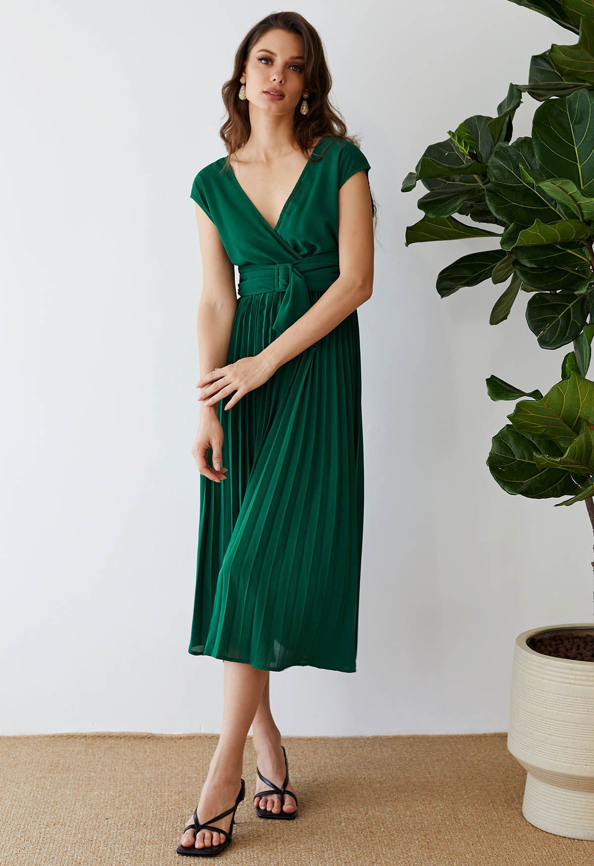 فستان أخضر بلا أكمام ملفوف بطيات مزين بالوشاح