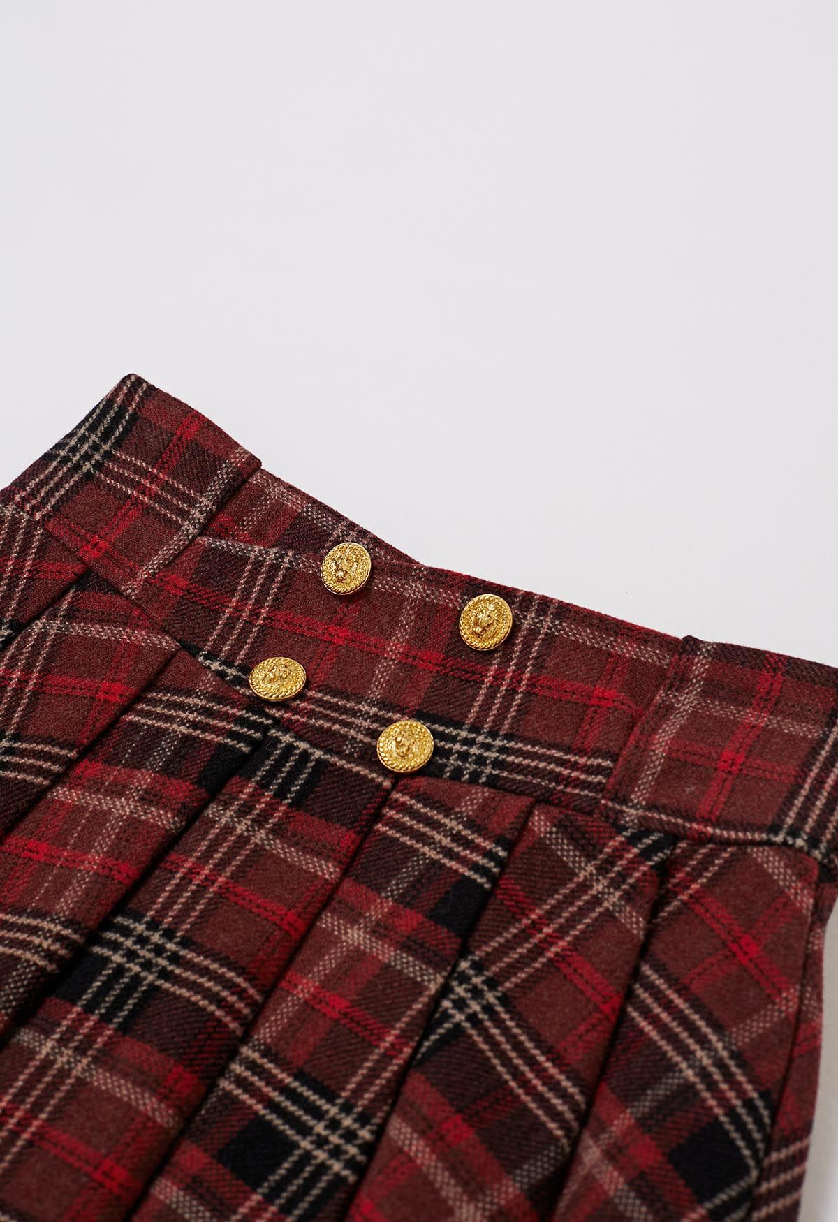 تنورة قصيرة ذات ثنيات مصنوعة من مزيج الصوف بأزرار ذهبية باللون العنابي المنقوش