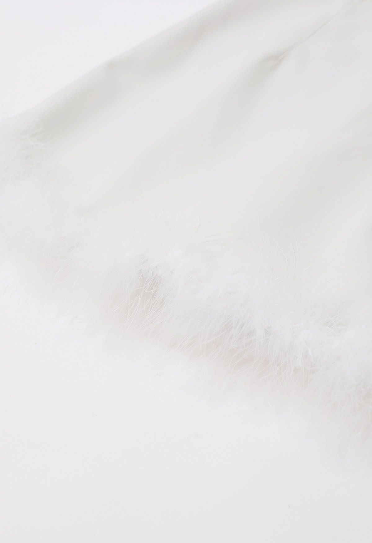 تنورة قصيرة من الجلد الصناعي بحاشية ريش باللون الأبيض
