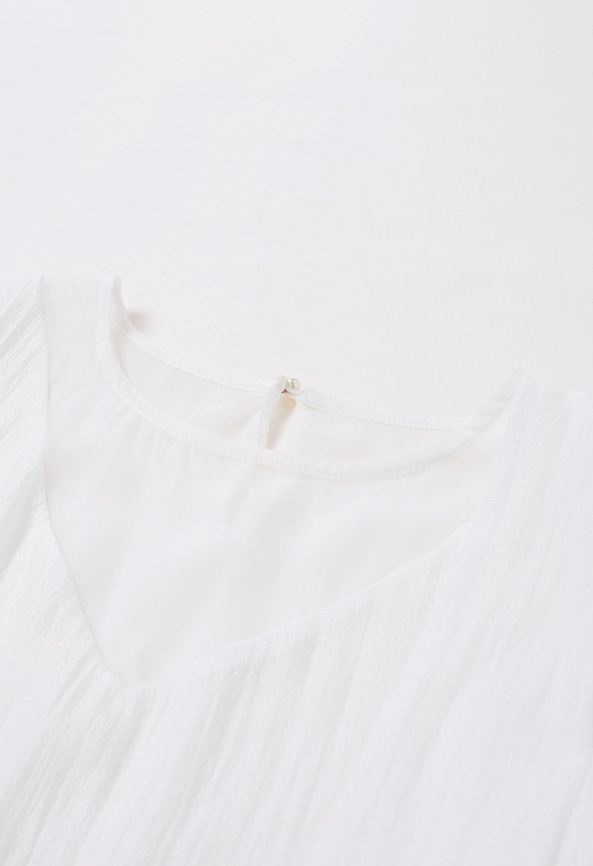 بلوزة شفافة ذات ربطة عنق جانبية باللون الأبيض