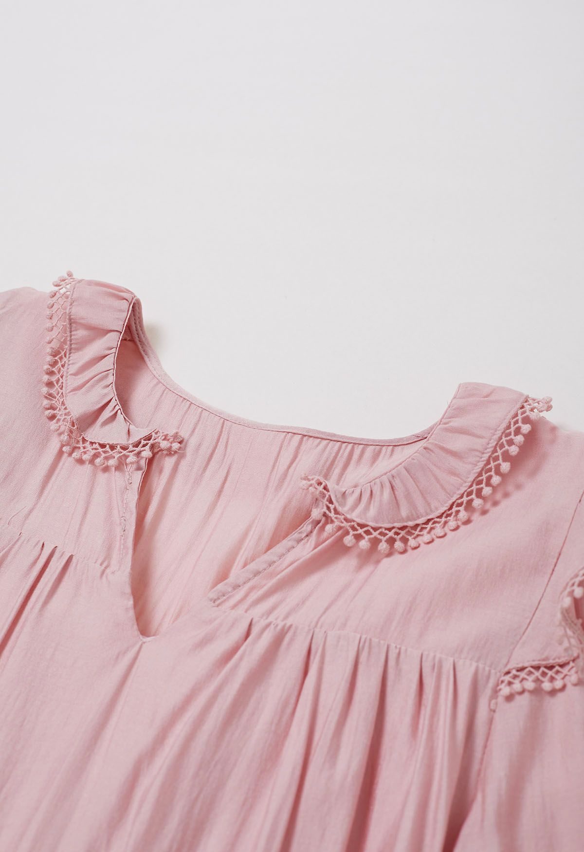 فستان قصير بأكمام متدرجة وتفاصيل هامشية باللون الوردي