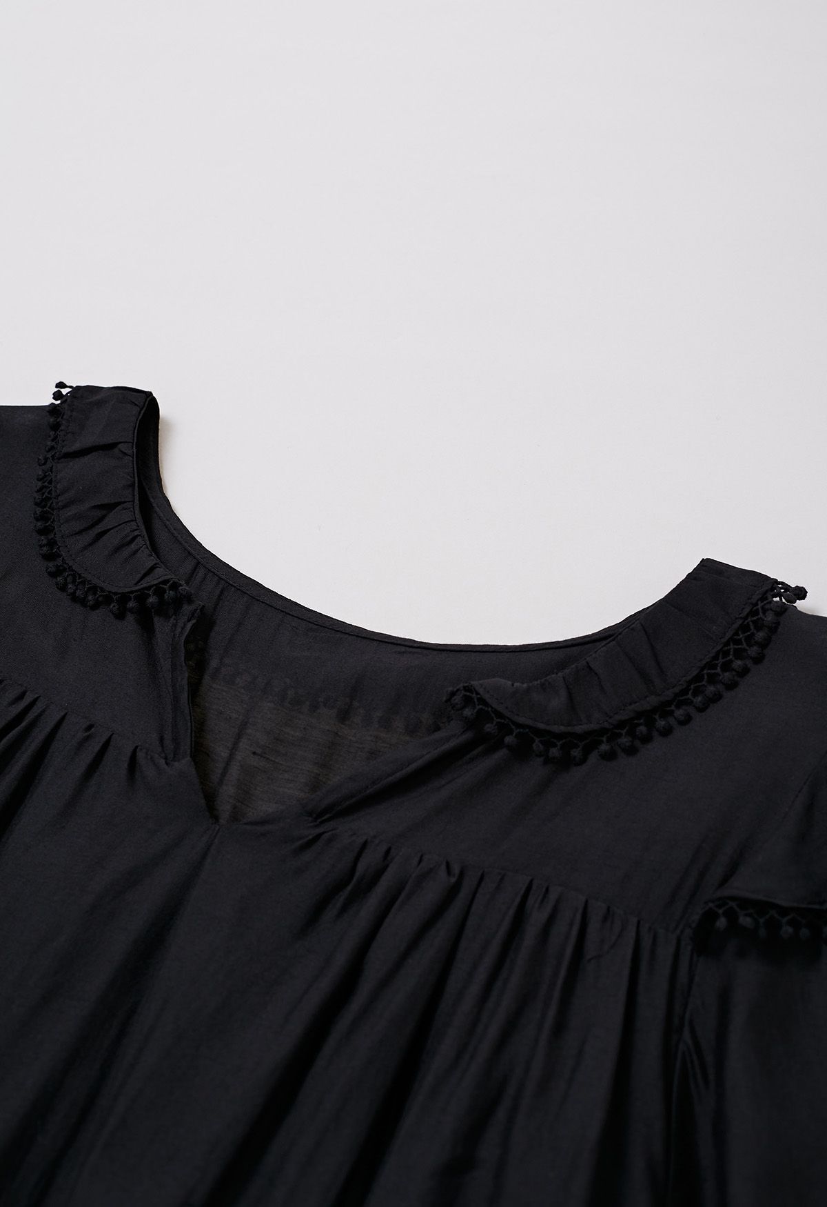 فستان قصير بأكمام متدرجة وتفاصيل هامشية باللون الأسود