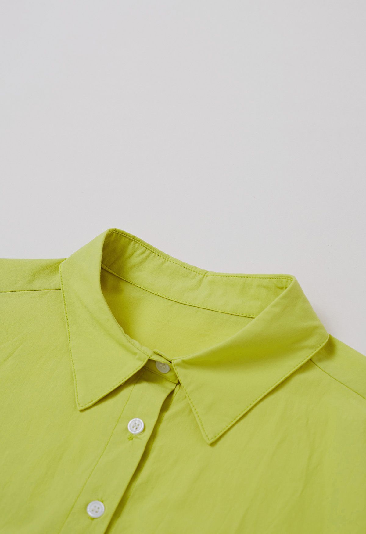 قميص قصير أنيق بأزرار سفلية باللون الليموني